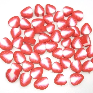 Close-up of red strawberry polymer clay beads for DIY jewelry and handmade crafts