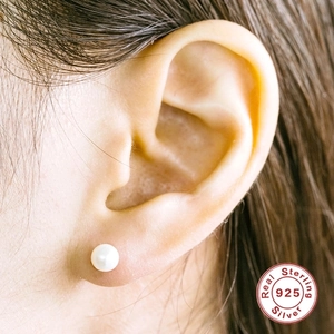 Elegant 925 sterling silver pearl stud earring shown on a model's earlobe for scale