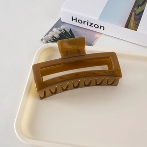 Detail of 13cm large amber claw clip for thick hair on a minimalist decorative tray