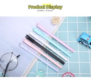 Detailed view of six colorful cat-shaped gel pens arranged on a blue checkered desk mat