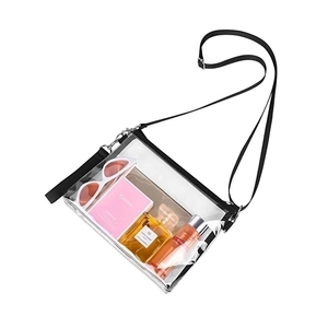 Close-up of a clear PVC crossbody bag showing capacity for cosmetics and sunglasses