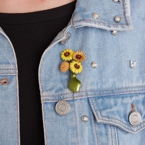 Enamel sunflower bouquet brooch pinned on a denim jacket for a floral fashion look