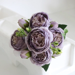 Detailed close-up of purple silk peony bouquet with blooming heads and green buds