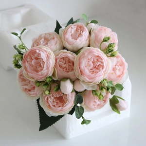 Top view of pink silk peony bouquet with detailed petals and delicate green leaves