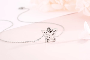 Detail of silver hollow butterfly pendant necklace with sparkling stones on pink background