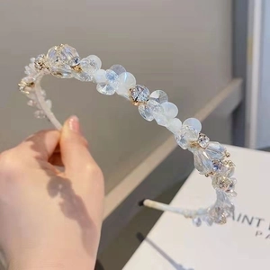 Exquisite handmade crystal beaded headband with pearl accents on a white fabric base