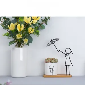Detail of ceramic succulent planter with wooden base and girl-shaped iron stand