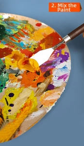 Detail shot of stainless steel palette knife mixing bright yellow paint on a wooden surface