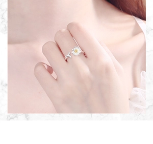 Detailopname van een verstelbare zilveren ring met witte madeliefje en een blad