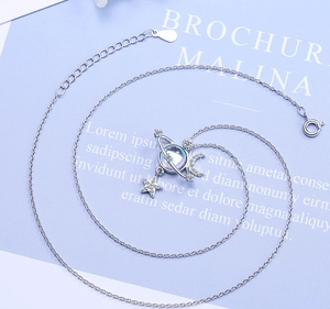 Macro view of S925 silver star and moon pendant with zircons on purple background