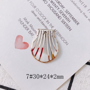 Detailed macro view of a 30mm gold-edged white enamel shell pendant for DIY jewelry