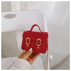 Detail of red glossy mini jelly bag with gold chains and double buckle hardware