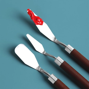 3-piece set of stainless steel painting knives with wooden handles on blue background