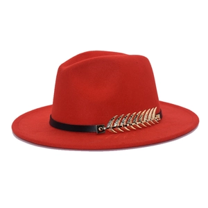 Detail of red wool fedora hat featuring a slim black band and golden leaf accent
