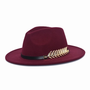 Detail of burgundy fedora with black leather band and golden leaf rhinestone ornament