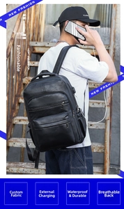 Detail of waterproof black PU leather backpack showing USB charging port and breathable back