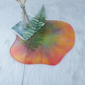 Detailed top view of an irregular resin coaster with rainbow gradient on white fur