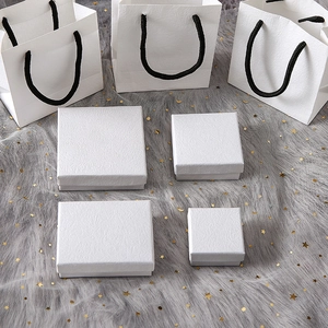 White textured jewelry boxes and gift bags set on a grey fur background with stars
