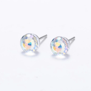 Close-up of faceted crystal ball stud earrings with iridescent rainbow reflections