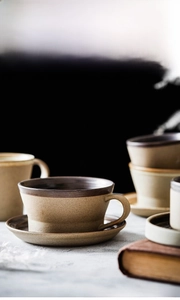 Macro view of matte stoneware coffee cup with vintage ceramic saucer and earthy brown glaze