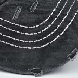 Dettaglio macro in cotone grigio con cuciture a contrasto e strappi stile vintage