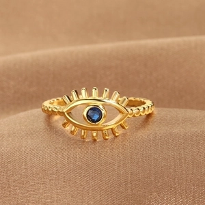 Gold-plated Evil Eye open ring with blue stone on luxury brown satin background