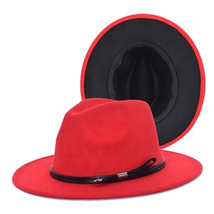 Close-up of a bright red wool fedora with a black band and detailed inner lining