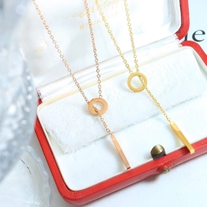 Elegant 18k gold and rose gold OT buckle tassel necklace in a luxury red velvet jewelry box