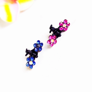 Détail de mini pinces à cheveux fleurs en strass bleues et roses pour coiffure enfant
