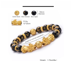 Close-up of 10mm black onyx beads with golden Pi Xiu charms and Buddhist mantras