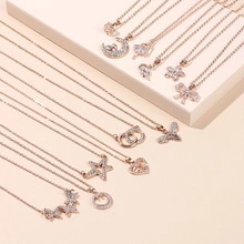 Detail view of rose gold pendants including butterfly, star, moon and heart designs with zircons