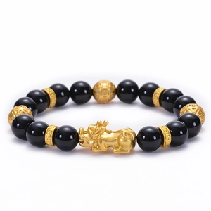 Detailed view of black obsidian beads and golden Pixiu charm with intricate patterns