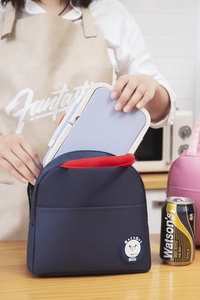 Insulated blue fabric lunch bag with red handles and a portable purple bento box
