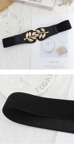 Detail of gold leaf buckle on elastic black waist belt with high stretch fabric