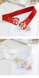 Close-up of golden leaf buckles on red and white elastic belts for women dresses