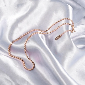 Macro shot of rose gold bead chain on satin with K18 engraving on the tag