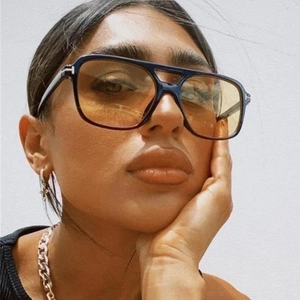 Detail of pilot sunglasses with orange gradient lenses and metal T-shape hinge accent