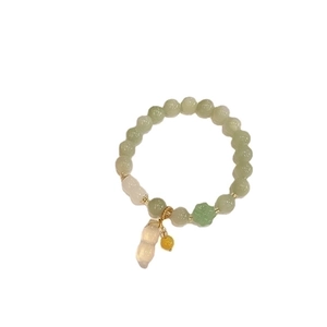 Retro light green jade beaded bracelet with peanut pendant and golden accents on white background