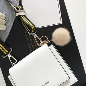 White square PU leather crossbody bag with a striped fabric strap and mink fur ball charm
