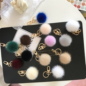 Detailed view of colorful mink fur pompom keychains with golden metal ring and lobster clasp