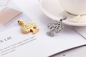 Detail of tree of life pendants in gold and silver finish on decorative card
