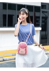 Détail d'un mini sac à dos rose à paillettes avec oreilles de chat et logo doré sur modèle