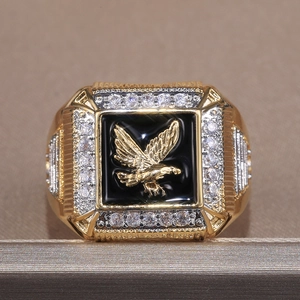 Close-up of golden eagle relief ring with black enamel and sparkling pavé setting