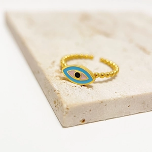 Macro detail of golden beaded adjustable ring with colorful enamel evil eye charm