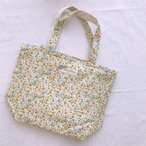 Détail du petit sac en coton à fleurs jaunes avec fermeture éclair et étiquette