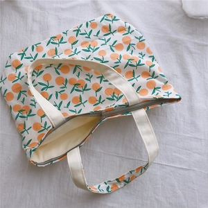 Gros plan détaillé d'un sac cabas en toile à motif orange avec fermeture éclair sécurisée