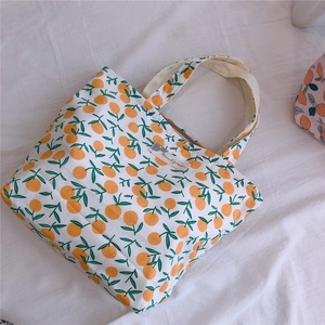 Gros plan d'un sac en toile avec motifs d'orange et une étiquette rectangulaire cousue