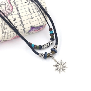 Ethnic sun pendant necklace with black braided cord and colorful beads on map box