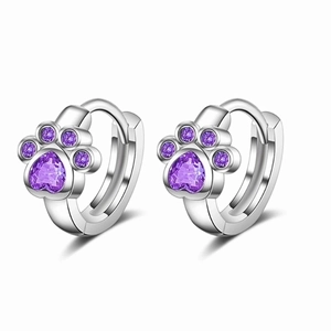Close-up of silver cat paw earrings with purple heart zircon and claw settings