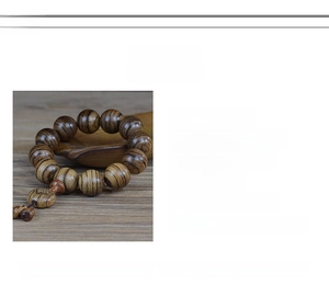 Macro detail of 108 agarwood beads bracelet from Vietnam showing natural wood texture